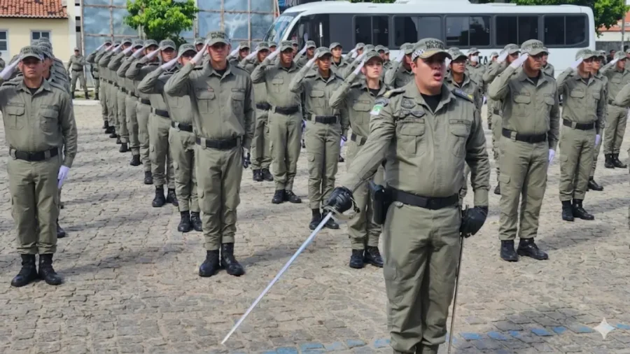 Formação de policiais militares da PMRN em continência durante cerimônia de instrução com oficial à frente segurando espada.