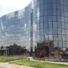 Prédio moderno de fachada espelhada com vários andares, refletindo o céu e a paisagem ao redor, com área externa gramada e rampas de acesso na entrada. Foto: Divulgação/Prefeitura de Paracatu-MG