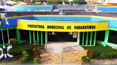 Processos Seletivos 9 Fachada colorida do prédio da Prefeitura Municipal de Paranatinga com entrada central, jardim com flores e bandeiras do Brasil ao lado. Foto: Divulgação/Prefeitura de Paranatinga-MT