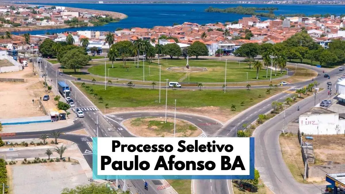 Paulo Afonso (BA) lança Processo Seletivo com 165 vagas 1 Vista aérea de uma grande rotatória arborizada em Paulo Afonso, na Bahia, com ruas asfaltadas ao redor, veículos em circulação e áreas residenciais ao fundo. A imagem destaca o urbanismo organizado da cidade, próxima a um lago visível no horizonte. Em primeiro plano, há uma faixa informativa com os dizeres “Processo Seletivo Paulo Afonso BA”, indicando chamada para seleção pública no município.