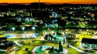 Vista noturna de Pojuca na Bahia com parque iluminado, quadra esportiva e cidade ao fundo sob céu alaranjado. Foto: Divulgação/Prefeitura de Pojuca-BA