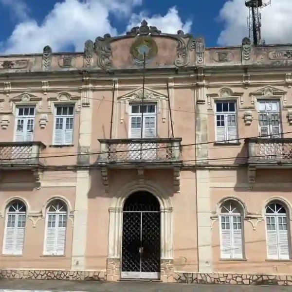 Prédio histórico de dois andares com fachada em estilo clássico, janelas e portas brancas, localizado em Pojuca, Bahia. Foto: Divulgação/Prefeitura de Pojuca–BA
