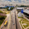 Vista aérea de avenida movimentada em Anápolis com prédios públicos, tráfego de veículos, áreas verdes e bandeira do município ao centro. Foto: Divulgação/Prefeitura de Anápolis-GO