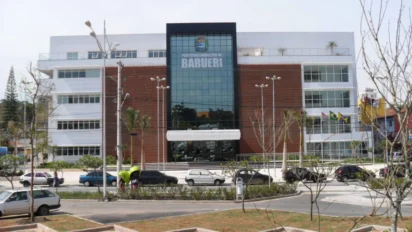Fachada do prédio da Prefeitura Municipal de Barueri, com edifício moderno, vidro central, nome do município em destaque e veículos estacionados em frente. Foto: Divulgação/Prefeitura de Barueri-SP