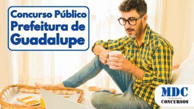 Homem sentado em uma cama com notebook no colo, vestindo camisa xadrez amarela e jeans, segurando uma caneca branca e olhando para a tela, com uma bandeja de café da manhã ao lado contendo torradas e suco - Prefeitura de Guadalupe (PI) abre 175 vagas com salários de até R$ 7 mil em Concurso Público