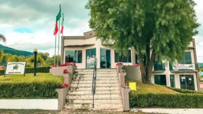 Prédio da Prefeitura de Ibiam SC com escadaria central, bandeiras hasteadas, jardim arborizado e fachada administrativa em destaque. Foto: Divulgação/Prefeitura de Ibiam-SC