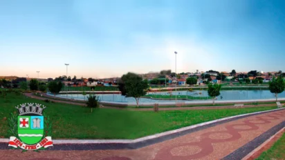 Vista panorâmica de área urbana de Itaí com lago, pista de caminhada, áreas verdes, casas ao fundo e brasão do município no canto da imagem. Foto: José Reynaldo da Fonseca/Wikimedia
