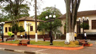 Processos Seletivos 7 Praça arborizada em frente à Prefeitura de Monteiro Lobato/SP, com bancos, postes de luz antigos e edifícios coloniais ao fundo. Foto: Divulgação/Prefeitura de Monteiro Lobato-SP