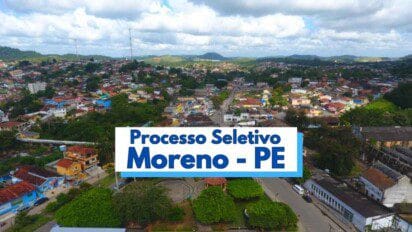 Vista panorâmica da cidade de Moreno, em Pernambuco, com destaque para a área urbana composta por casas coloridas, vegetação densa e relevo com morros ao fundo. No centro da imagem, há uma faixa com os dizeres “Processo Seletivo Moreno - PE” em letras azuis, indicando a abertura de vagas pela prefeitura local. O céu está parcialmente nublado, com iluminação natural suave.