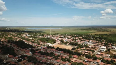 Vista aérea de Parnaguá mostrando casas, áreas verdes e uma lagoa ao fundo sob céu aberto com poucas nuvens. Foto: Divulgação/Prefeitura de Parnaguá-PI