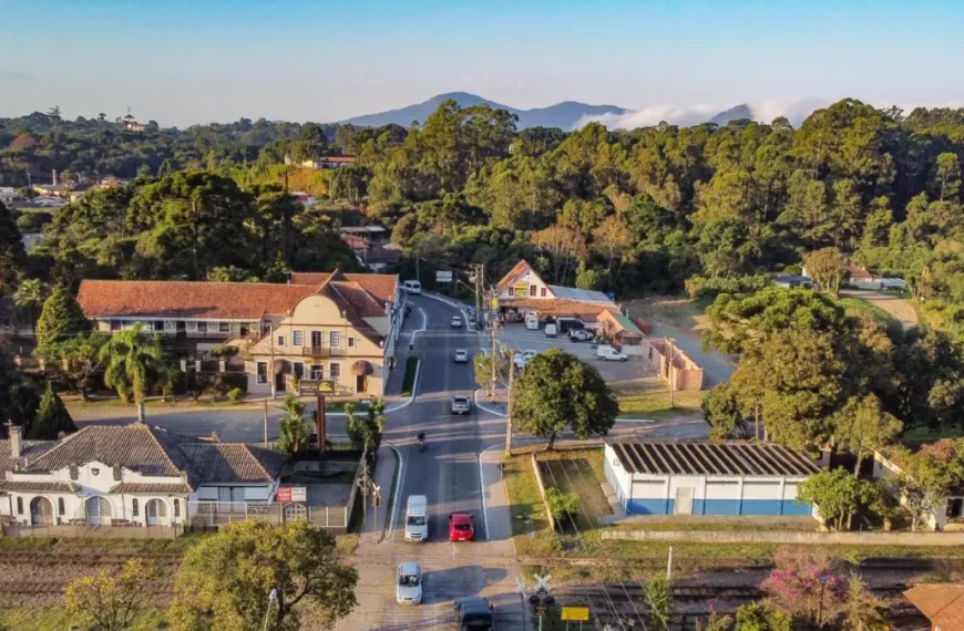 Vista aérea de área urbana de Piraquara com casas, avenida principal, linha férrea e vegetação ao redor. Foto: Divulgação/Prefeitura de Piraquara-PR