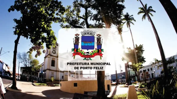 Vista de uma praça ensolarada em Porto Feliz com árvores, bancos e uma igreja ao fundo. Centralizado, o brasão da cidade sobrepõe a imagem com o texto Prefeitura Municipal de Porto Feliz.