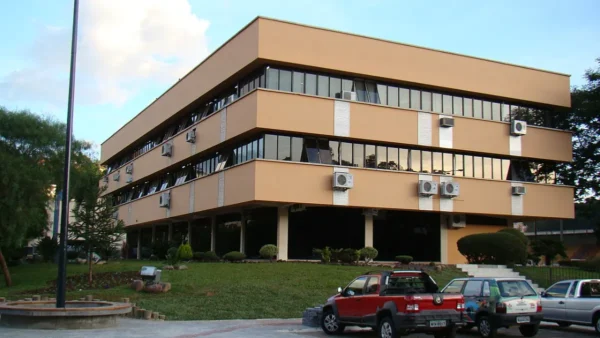 Prefeitura de Videira/SC abre processo seletivo com salários de até R$ 5,7 mil 5 Prédio da Prefeitura Municipal de Videira, em Santa Catarina, com fachada moderna em tons claros, janelas amplas, ar-condicionado externo, área verde e veículos estacionados à frente. Foto: Matheus Giusti/Wikipédia