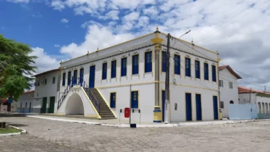 Processos Seletivos 8 Prédio histórico branco com detalhes azuis e amarelos, processo seletivo Alcobaça BA