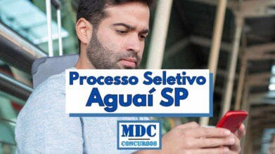 Processos Seletivos 5 Homem de barba e cabelos escuros em ambiente interno, olhando para a tela de um celular vermelho com expressão concentrada, vestindo camiseta cinza clara e mochila nas costas, com sobreposição de texto centralizado em destaque dizendo Processo Seletivo Aguaí SP em letras azuis, e logotipo da MDC Concursos na parte inferior central da imagem em fonte azul com moldura azul clara