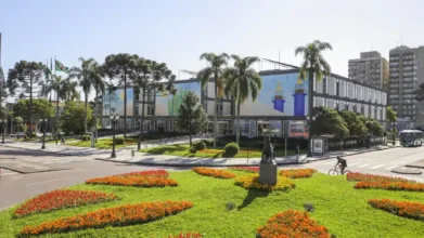 Fachada da Prefeitura Municipal de Curitiba com jardins floridos em destaque, ilustrando a abertura do processo seletivo Curitiba para o cargo de engenheiro civil