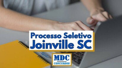 Pessoa digitando em um notebook com um caderno amarelo e uma caneta ao lado, em uma mesa cinza. Sobre a imagem, há um banner com os dizeres “Processo Seletivo Joinville SC” em letras azuis e destacadas, além do logotipo “MDC Concursos” em azul dentro de um quadro dourado, indicando que se trata de uma oportunidade de seleção pública no município de Joinville, Santa Catarina
