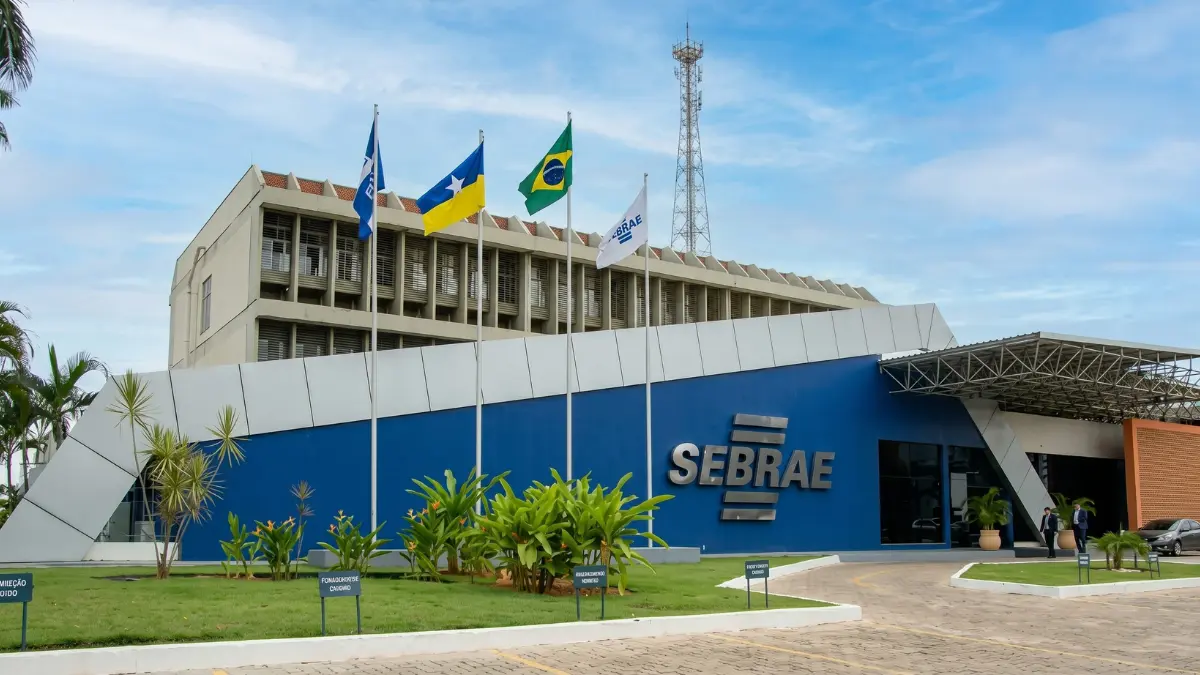 Processo Seletivo SEBRAE TO abre vagas com salários de até R$ 4.788,00 1 Fachada do SEBRAE com logotipo em azul e bandeiras ao fundo, sede do processo seletivo SEBRAE TO