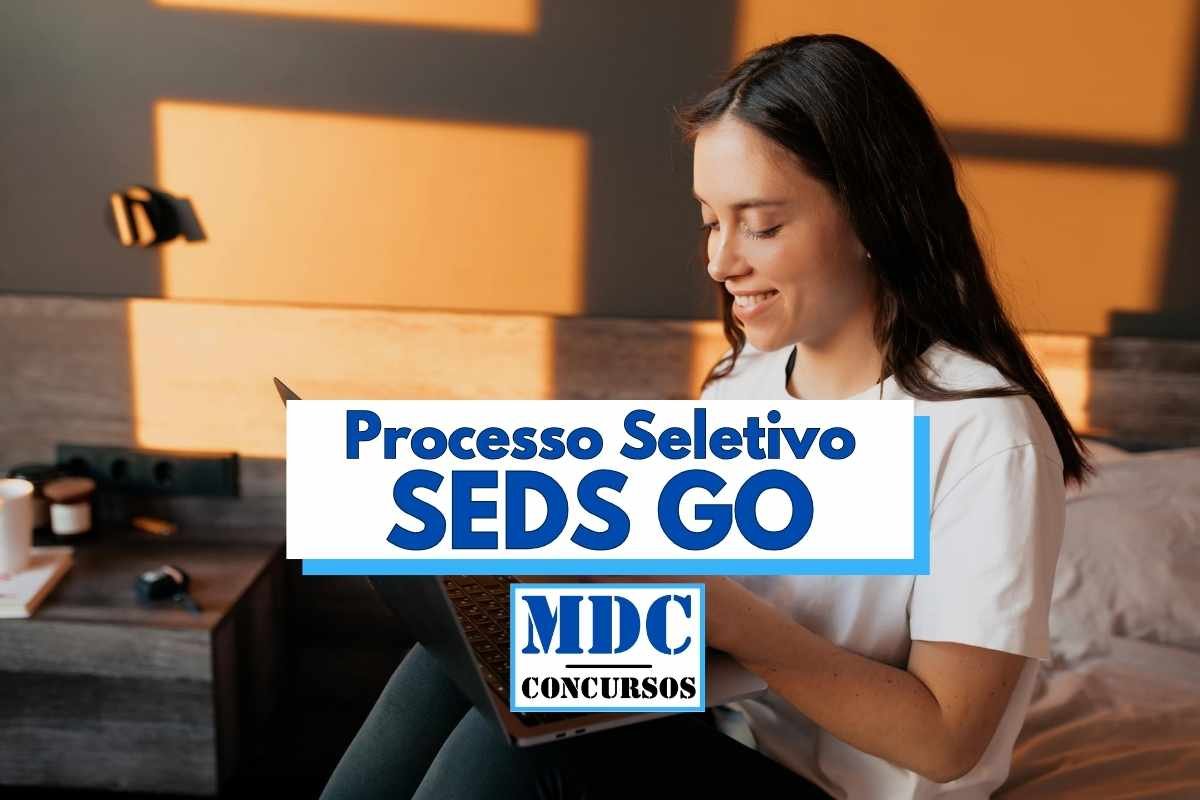 Processo Seletivo SEDS GO abre 94 vagas de até R$ 10,8 mil 1 Mulher jovem com cabelos castanhos longos e lisos, vestindo camiseta branca, está sentada em um quarto com decoração moderna, sorrindo enquanto utiliza um notebook no colo; ao centro da imagem há uma sobreposição gráfica com os dizeres "Processo Seletivo SEDS GO" em letras azuis e "MDC Concursos" em destaque na parte inferior da arte