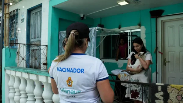 Vacinadora com camiseta da Prefeitura de Manaus atende moradora no processo seletivo Semsa Manaus