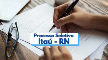 A imagem mostra uma pessoa preenchendo um formulário com uma caneta preta sobre uma mesa de madeira. Ao lado, há um par de óculos e papéis empilhados. No centro da imagem, há uma faixa com os dizeres "Processo Seletivo Itaú - RN" em letras azuis, destacando um concurso público ou seleção de vagas na cidade de Itaú, no estado do Rio Grande do Norte.