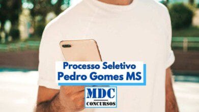Processos Seletivos 8 Homem usando camiseta branca segura um smartphone dourado enquanto olha para a tela. Em destaque, no centro da imagem, há um texto promocional que diz "Processo Seletivo Pedro Gomes MS", acompanhado do logotipo da MDC Concursos. Ao fundo, o cenário é externo, com iluminação natural e presença de árvores e estrutura urbana desfocada. A imagem promove uma seleção pública no município de Pedro Gomes, MS.