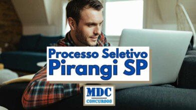 Homem jovem de barba curta e cabelo castanho claro usando camisa xadrez vermelha e azul, sentado em um sofá escuro e olhando para a tela de um notebook prateado em um ambiente iluminado por luz natural, com móveis modernos ao fundo, sobre a imagem há um banner escrito Processo Seletivo Pirangi SP em letras grandes azuis e o logo MDC Concursos abaixo