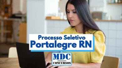 Mulher de cabelos longos e lisos, vestindo blusa amarela, está sentada à mesa utilizando um notebook com expressão atenta. O ambiente ao fundo é claro e moderno, com móveis e utensílios que sugerem uma cozinha ou espaço de convivência. Sobre a imagem, há um banner com o texto “Processo Seletivo Portalegre RN” e o logotipo “MDC Concursos”, destacando tema relacionado a concursos públicos.
