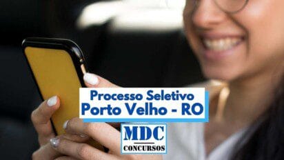 Imagem mostra uma mulher sorridente utilizando um smartphone com capa amarela, sugerindo que está acessando informações online. Em destaque no centro da imagem, há uma faixa com os dizeres "Processo Seletivo Porto Velho - RO" em letras azuis, seguida pelo logotipo "MDC Concursos". A imagem transmite uma atmosfera positiva e remete à realização de inscrições digitais para um processo seletivo.