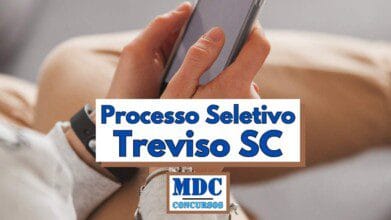 Processos Seletivos 6 Pessoa segurando um smartphone com as duas mãos, vestindo uma blusa clara e relógio no pulso esquerdo, em um ambiente interno com aparência confortável. Sobre a imagem há uma faixa com os dizeres "Processo Seletivo Treviso SC" em letras grandes e azuis. Abaixo, o logotipo da "MDC Concursos" também está presente em destaque centralizado