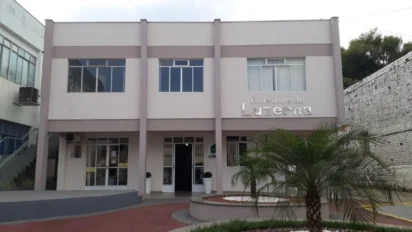 Fachada do prédio da Prefeitura de Luzerna com letreiro em destaque, palmeira à frente e estacionamento no processo seletivo Luzerna SC