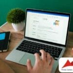 Homem visualiza um currículo digital em um notebook, com destaque para dados pessoais, resumo profissional e foto de perfil de um candidato chamado John Rogers. A cena se passa em um ambiente de trabalho organizado, com caderno, caneta, bloco de notas colorido, porta-lápis e um pequeno vaso decorativo sobre a mesa de madeira. No canto inferior direito, aparece o logotipo da MGS (Minas Gerais Administração e Serviços S.A.).