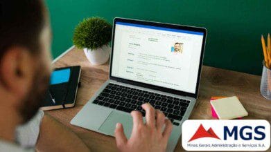 Processos Seletivos 3 Homem usa notebook para preencher currículo online; no canto da imagem aparece o logotipo da MGS (Minas Gerais Administração e Serviços S.A.).