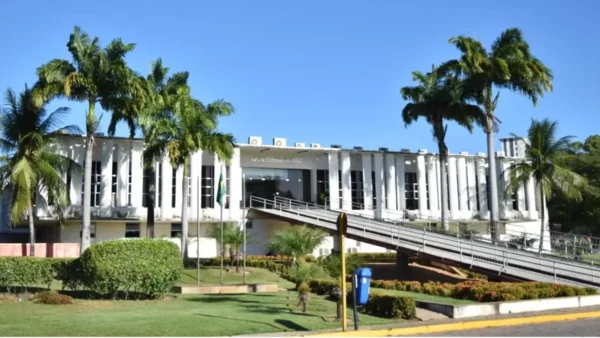 RN abre Concurso Unificado: Fachada do prédio da Governadoria do Rio Grande do Norte em Natal com gramado e palmeiras sob céu azul claro
