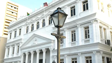 Fachada branca do Tribunal de Justiça do Maranhão com bandeiras e lanterna, sede da Residência Jurídica