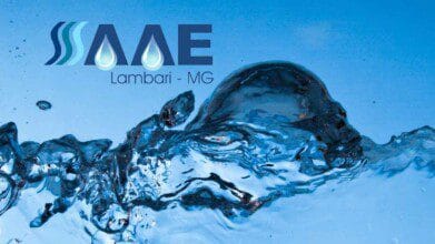 Logotipo do SAAE Lambari-MG sobre fundo azul com água em movimento.