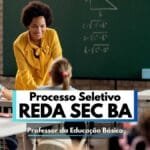 Imagem de uma sala de aula com crianças sentadas em carteiras escolares, vistas de costas, enquanto uma professora, sorridente, usa uma blusa amarela vibrante e interage com os alunos. Ao fundo, há um quadro verde com fórmulas matemáticas e o desenho de uma lâmpada, sugerindo uma aula de ciências ou matemática. Em destaque, um banner sobreposto informa “Processo Seletivo REDA SEC BA – Professor da Educação Básica”.