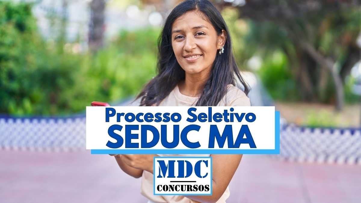 Mulher jovem de cabelos longos e escuros sorri enquanto segura um celular em ambiente ao ar livre com vegetação ao fundo. Na imagem, há uma faixa com os dizeres “Processo Seletivo SEDUC MA” em letras grandes e azuis, além do logotipo do site “MDC Concursos”. A imagem está relacionada a um processo seletivo para professores indígenas no Maranhão.