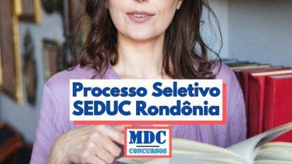 Mulher com blusa lilás segura um livro aberto em frente a uma estante com livros vermelhos ao fundo imagem parcialmente cortada mostra apenas parte do rosto e do tronco da pessoa no centro da imagem sobreposta por uma faixa com o texto Processo Seletivo SEDUC Rondônia em letras azuis e sombra vermelha na base inferior está o logotipo MDC Concursos em destaque