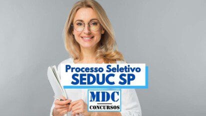 Imagem de uma mulher loira com cabelo liso, usando óculos de grau e sorrindo, segurando um caderno e uma caneta. Ela está vestindo uma blusa branca e está posicionada contra um fundo cinza claro. Na imagem há sobreposição de texto que diz: "Processo Seletivo SEDUC SP" e, logo abaixo, o logotipo "MDC Concursos", indicando a divulgação de um processo seletivo para a Secretaria da Educação do Estado de São Paulo.