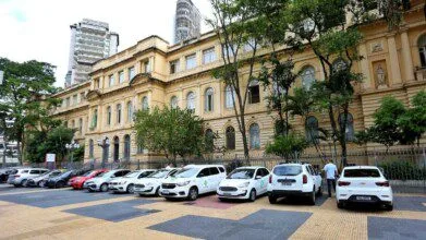 Fachada de prédio histórico da Secretaria da Educação do Estado de São Paulo com carros estacionados em frente.