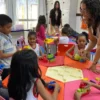 Professora auxilia crianças em sala de aula enquanto alunos pequenos brincam e montam blocos coloridos em mesas coletivas. Foto: Divulgação/Prefeitura de Marabá