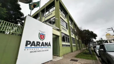 SESA/PR abre concurso com 641 vagas e salários de até R$ 9,8 mil 1 Fachada de prédio da Secretaria da Saúde do Paraná com placa do Governo do Estado e bandeiras hasteadas em área urbana. Foto: Divulgação/SESA-PR
