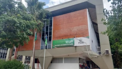 Prédio da Secretaria de Estado da Saúde do Piauí com fachada de tijolos, letreiro da SESAPI, bandeiras hasteadas e árvores ao redor. Foto: Divulgação/Governo do Piauí