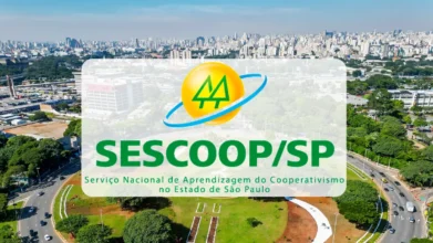 Logotipo do SESCOOP/SP centralizado sobre uma vista aérea da cidade de São Paulo. O símbolo apresenta um círculo amarelo com dois pinheiros verdes, envolto por um anel azul. Abaixo, o texto identifica o Serviço Nacional de Aprendizagem do Cooperativismo no Estado de São Paulo. Foto: Divulgação/Prefeitura de São Paulo