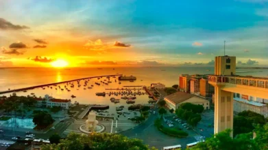 Vista aérea do Porto de Salvador ao pôr do sol, com embarcações na Baía de Todos-os-Santos, Elevador Lacerda à direita e prédios históricos ao redor do centro da cidade. Foto: Divulgação/Prefeitura de Salvador-BA