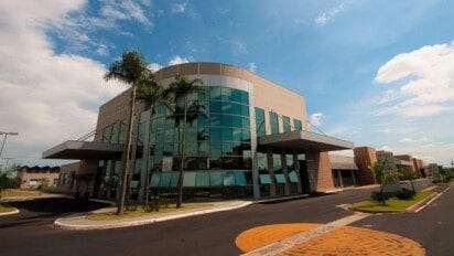 Hospital e Maternidade Dr. Odelmo Leão Carneiro em Uberlândia, administrado pela SPDM, com fachada moderna de vidro espelhado e paisagismo com palmeiras. Foto: Divulgação/SPDM