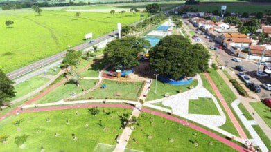 Processos Seletivos 6 Vista aérea de parque urbano em Santo Antônio de Goiás com área verde, pista de caminhada, playground, árvores e piscina ao lado de avenida e residências