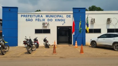Fachada da Prefeitura Municipal de São Félix do Xingu com prédio branco e azul, bandeiras oficiais na entrada e motocicletas estacionadas em frente. Foto: Divulgação/Prefeitura de São Félix do Xingu-PA