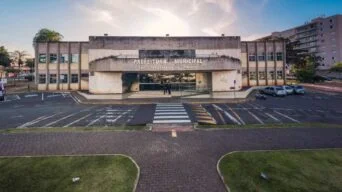 Prédio da Prefeitura Municipal de São Sebastião do Paraíso-MG, com fachada cinza, estacionamento em frente e céu parcialmente ensolarado ao fundo. Foto: Divulgação/Prefeitura de São Sebastião do Paraíso-MG